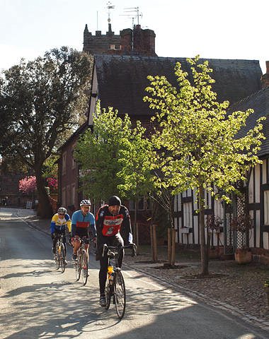 Cycling through the picturesque
        <br>village of Great Budworth